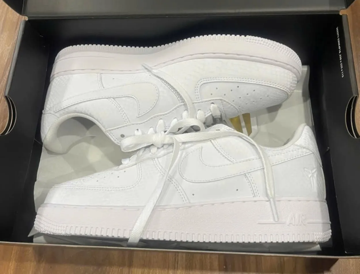 Side view of the all-white Kobe Bryant x Nike Air Force 1 Low in shoebox, showing snakeskin texture and Mamba branding