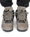 Front angle on-foot look at the Air Jordan 4 Cave Stone showing tongue and lacing