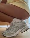 Close-up shot of Emily Oberg styling the Sporty & Rich x adidas Adistar Cushion "Grey" sneakers.