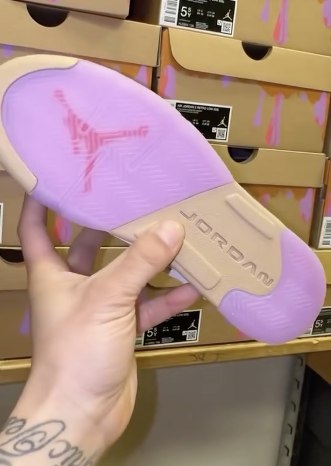 Close-up of Air Jordan 5 Low GS Peanut Butter & Jelly sneaker outsole with purple and red accents