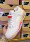 Air Jordan 5 Low GS Peanut Butter & Jelly sneaker held in hand showing white upper and gum sole