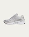 Side angle of the Sporty & Rich x adidas Adistar Cushion "Grey" highlighting mesh upper and metallic silver overlays.