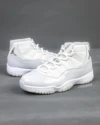Side view of the Air Jordan 11 “Grand Finale” featuring white patent leather and chrome Jumpman logo